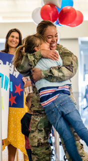 moms hugging their kids and smiling.