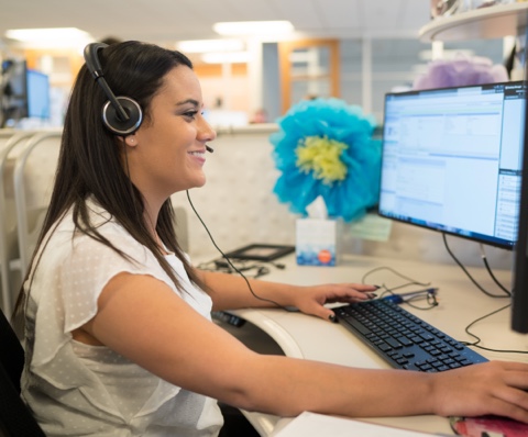 Proud USAA employee sitting in a cubicle with a headset on