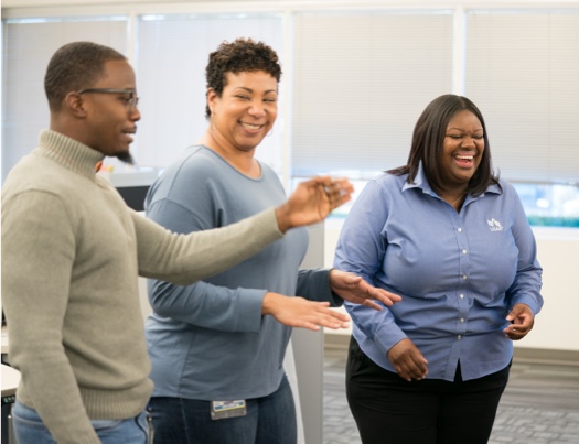 Three USAA employees (2 females and 1 male) socializing and having a great time with big smiles