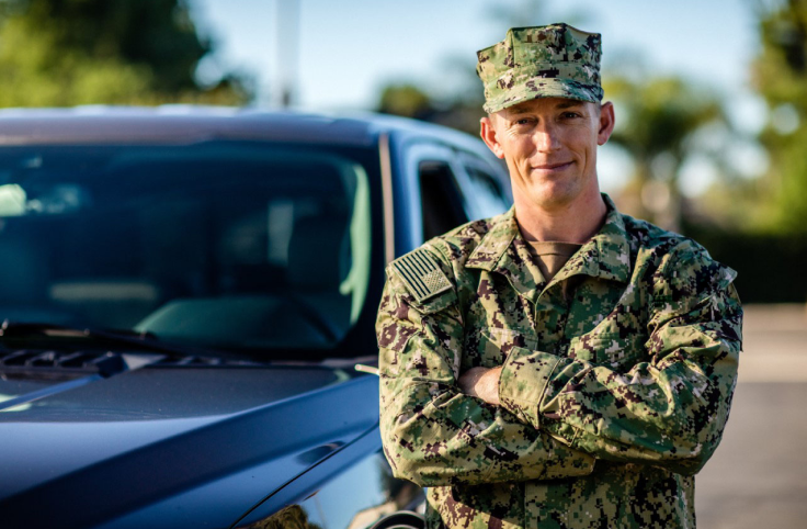 Military man in front of a car