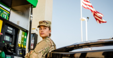 Military woman at gas pump