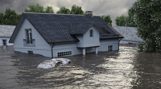 A car floats by some homes surrounded by high flood water.