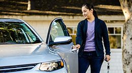 A person pulls open a driver's side car door.